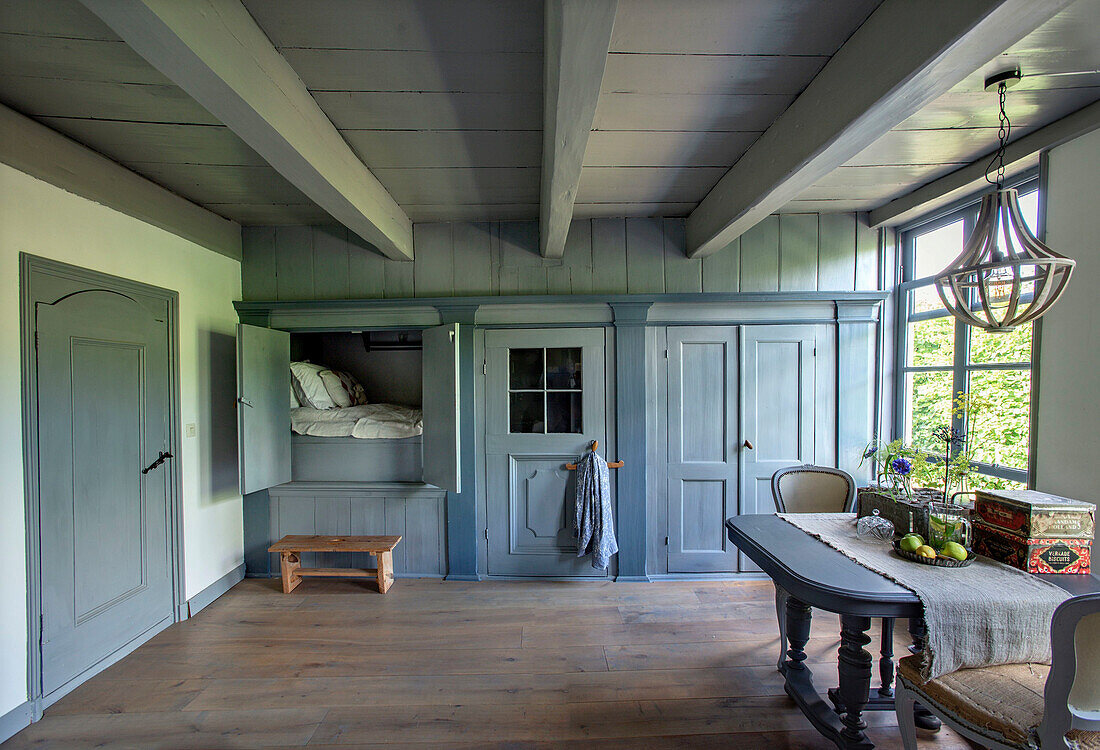 Traditionelles Schlafzimmer in Blau- und Grautönen mit Alkovenbett und Holzbalkendecke