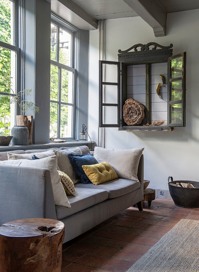 Grey living room with large windows and rustic wall shelf