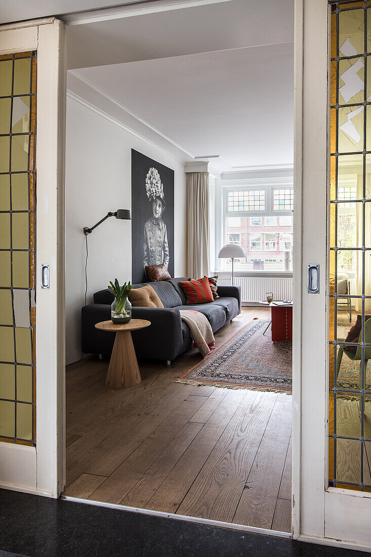 View through double doors to a modern living room with floorboards