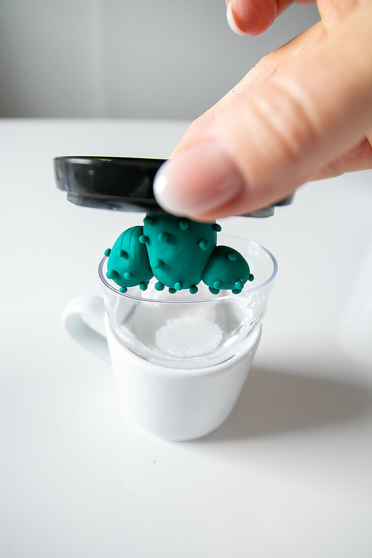 Homemade clay cactus being made into a snow globe