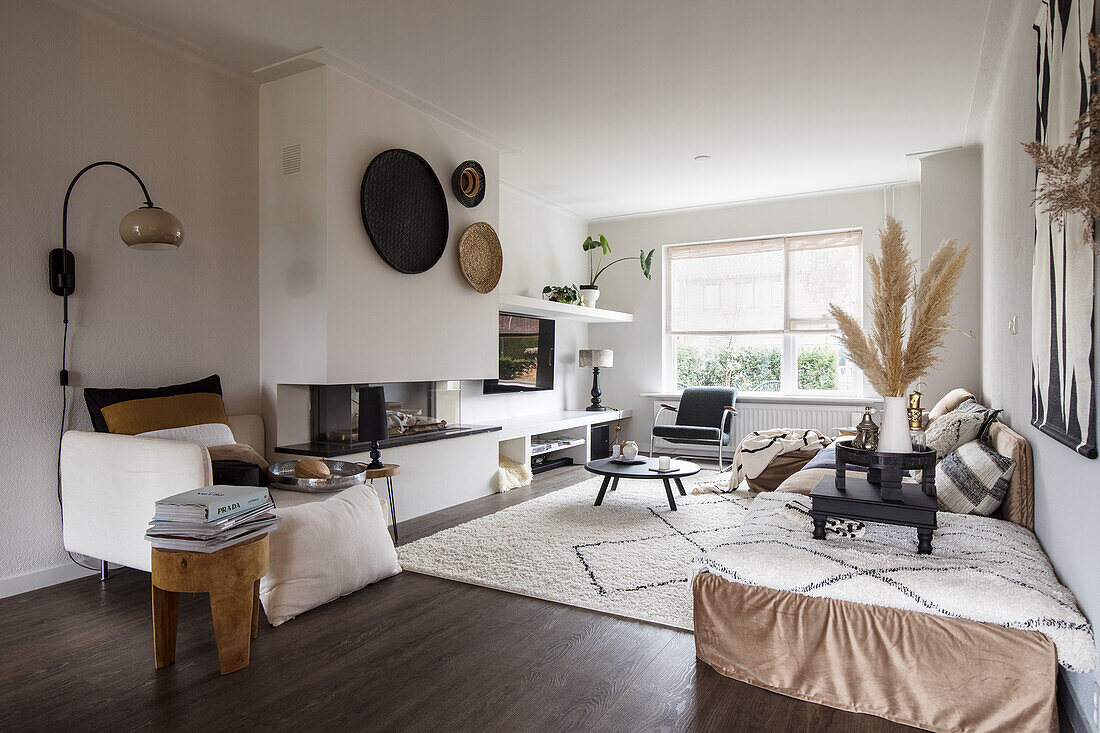 Living room with fireplace, wall decoration and textiles in earthy tones