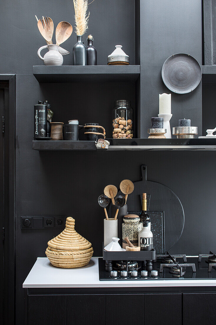 Black kitchen shelves with decorative utensils and spices