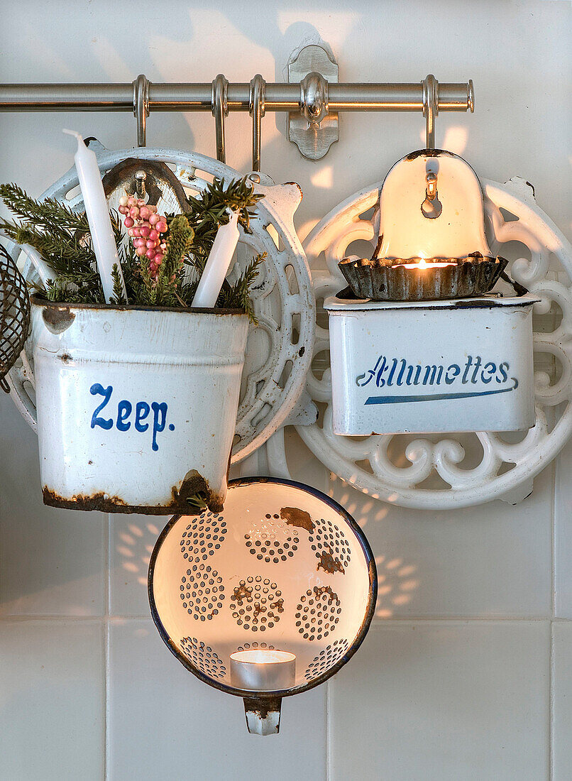 Enameled containers with candles, fir branches and tea lights