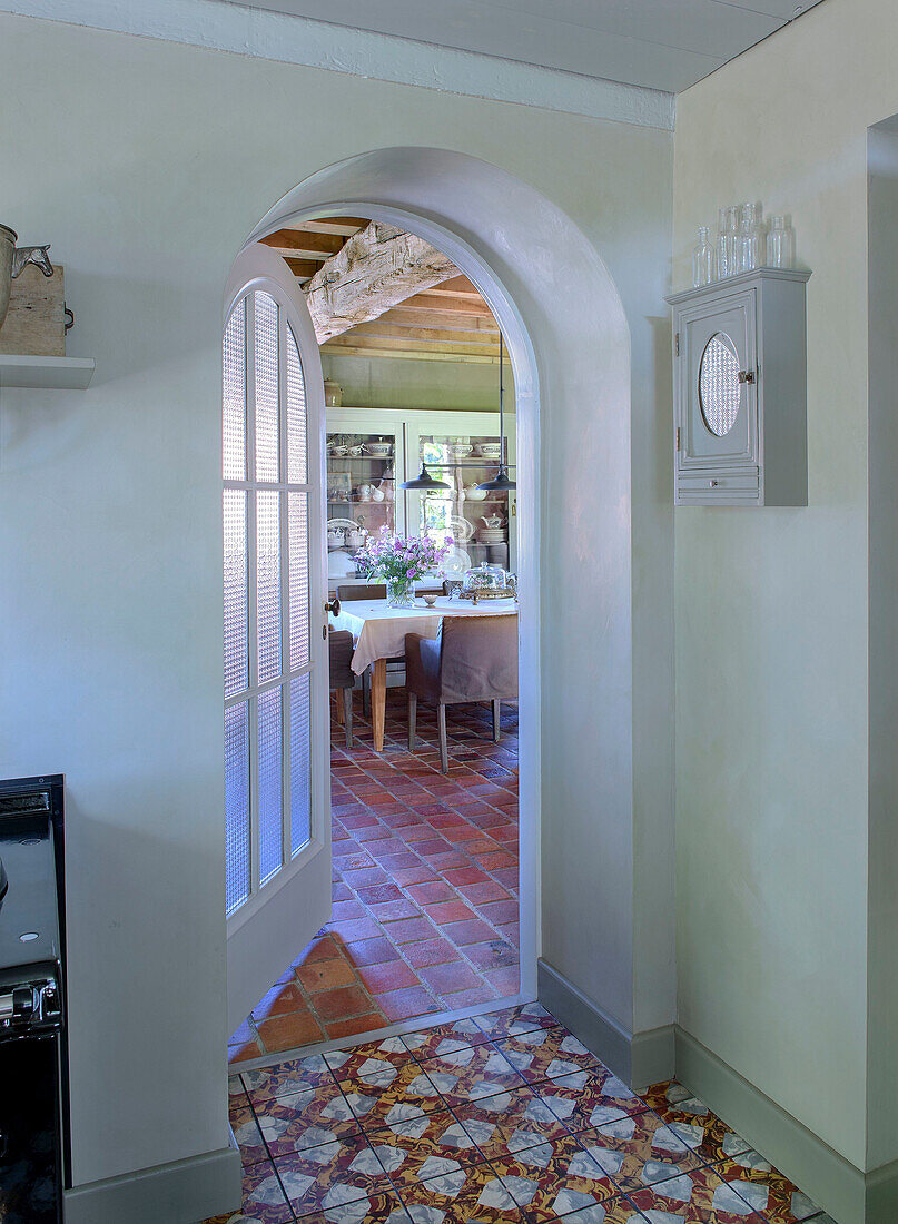 Blick aus der Küche durch geöffnete Rundbogentür auf Essbereich