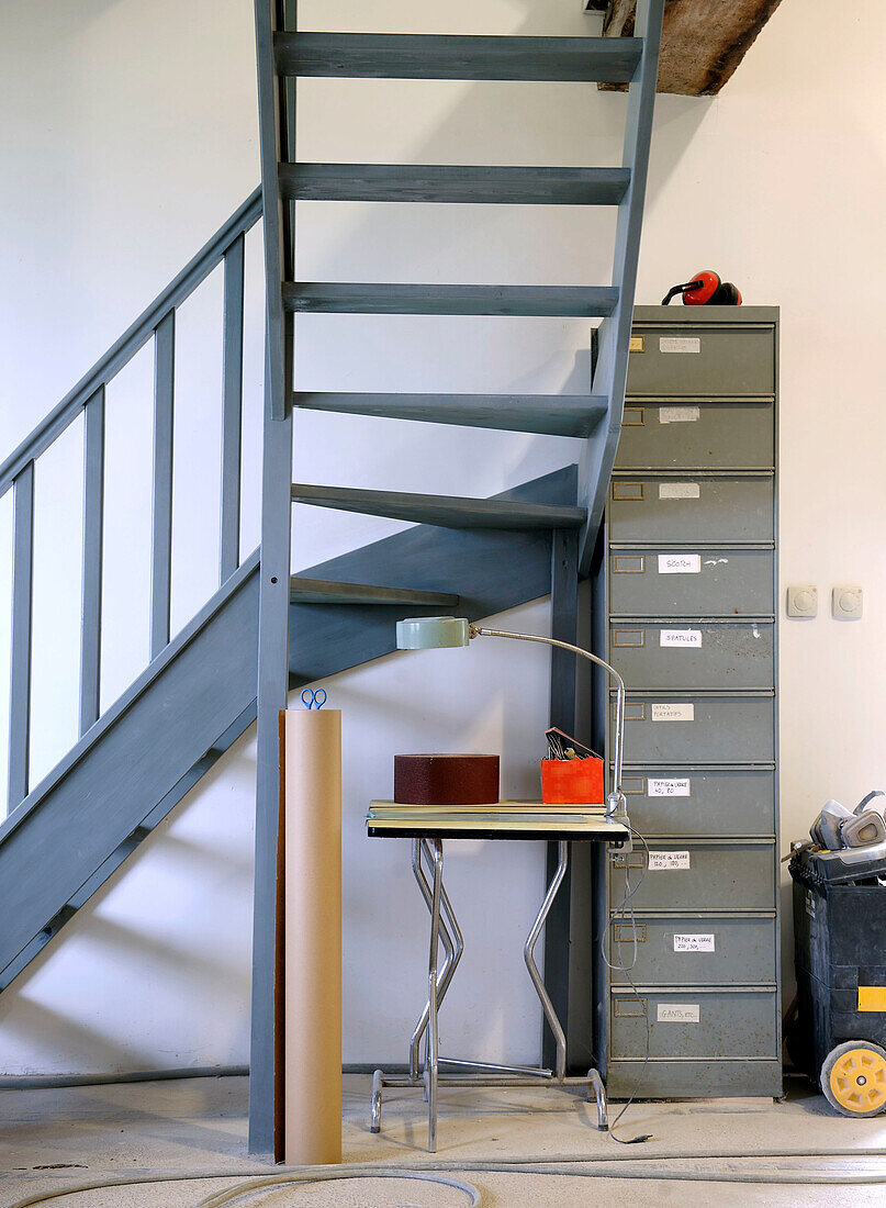 Werkstattecke mit Metalltreppe, Archivschrank und Tisch