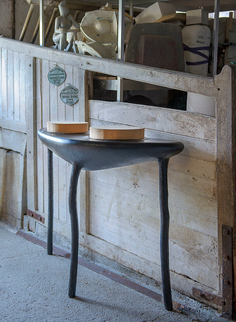 Modern black side table with an organic shape in a workshop