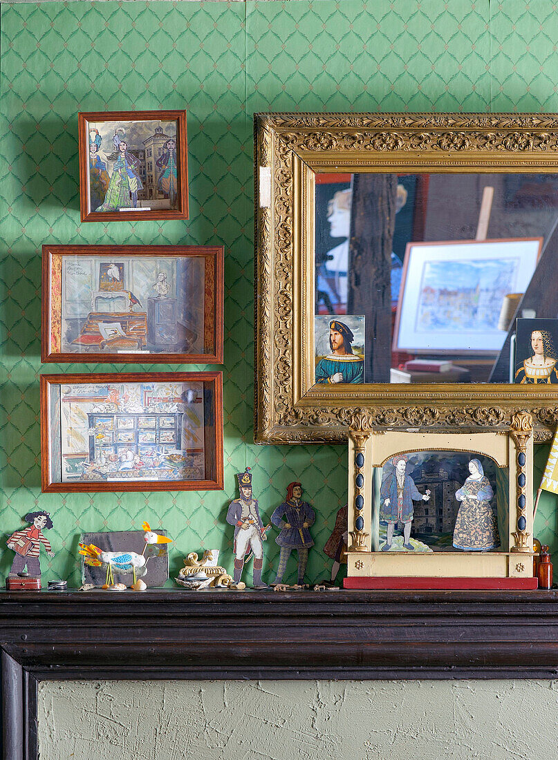 Antike Spielzeugsammlung vor grüner Wand mit Gemälden