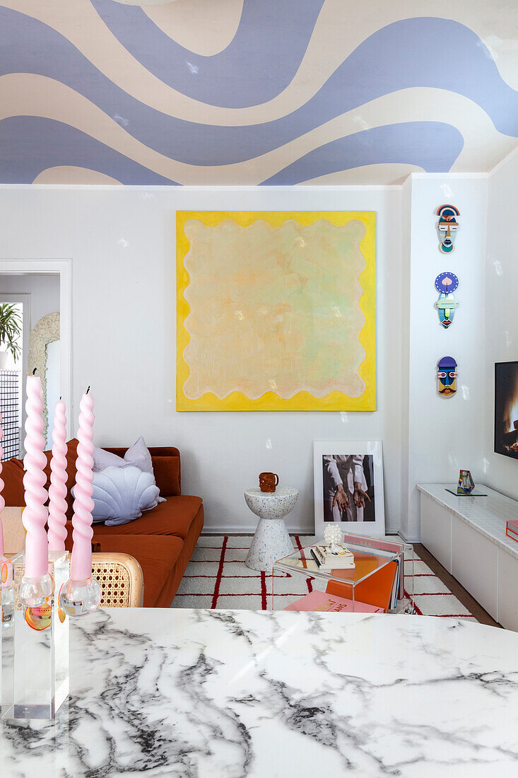 Living room with abstract ceiling, marble table and colorful wall decoration