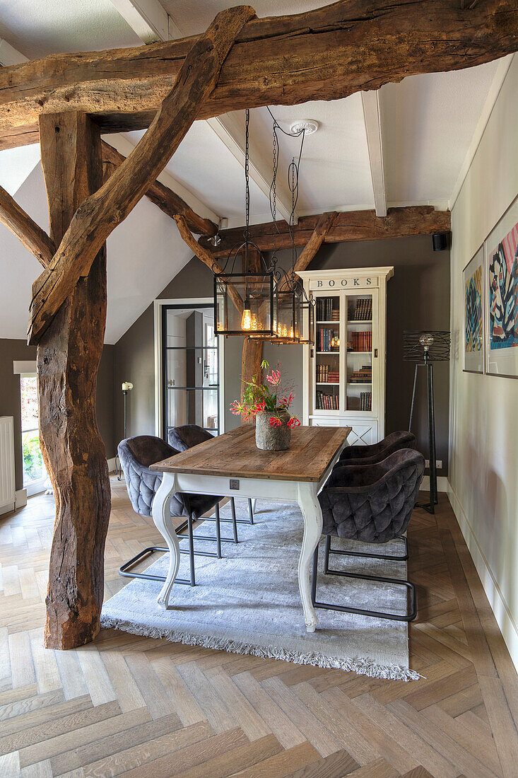 Dining area with rustic wooden table, exposed beams and pendant lights