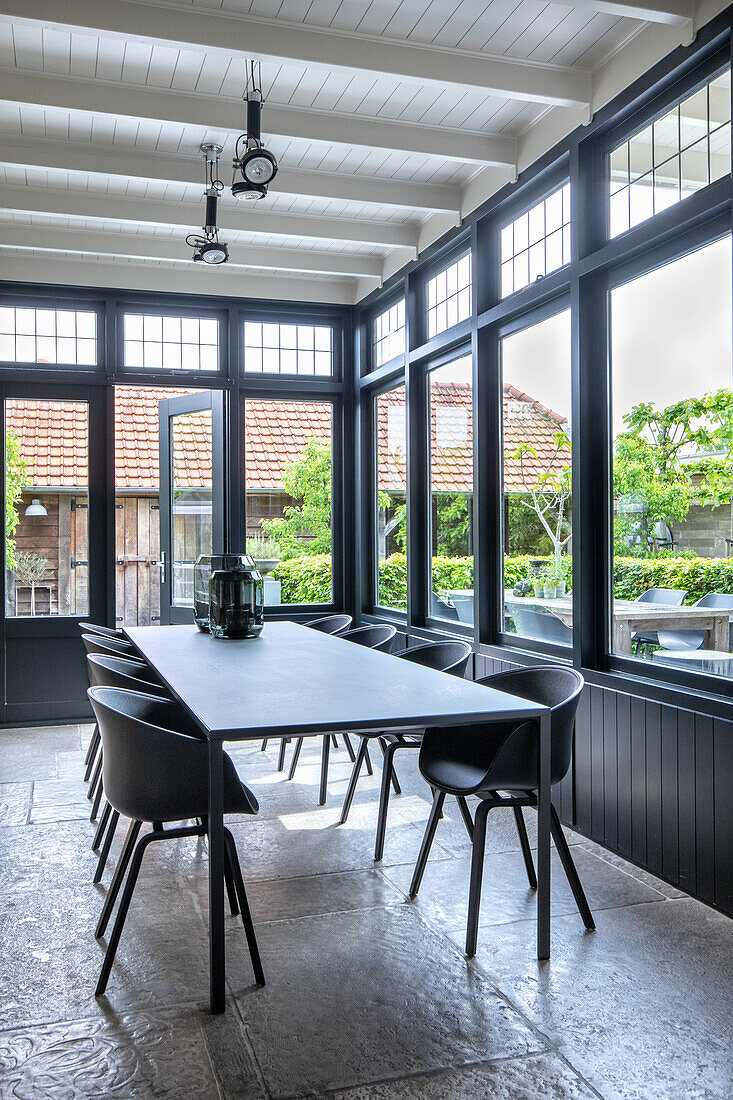 Dining area with large window front and black designer chairs