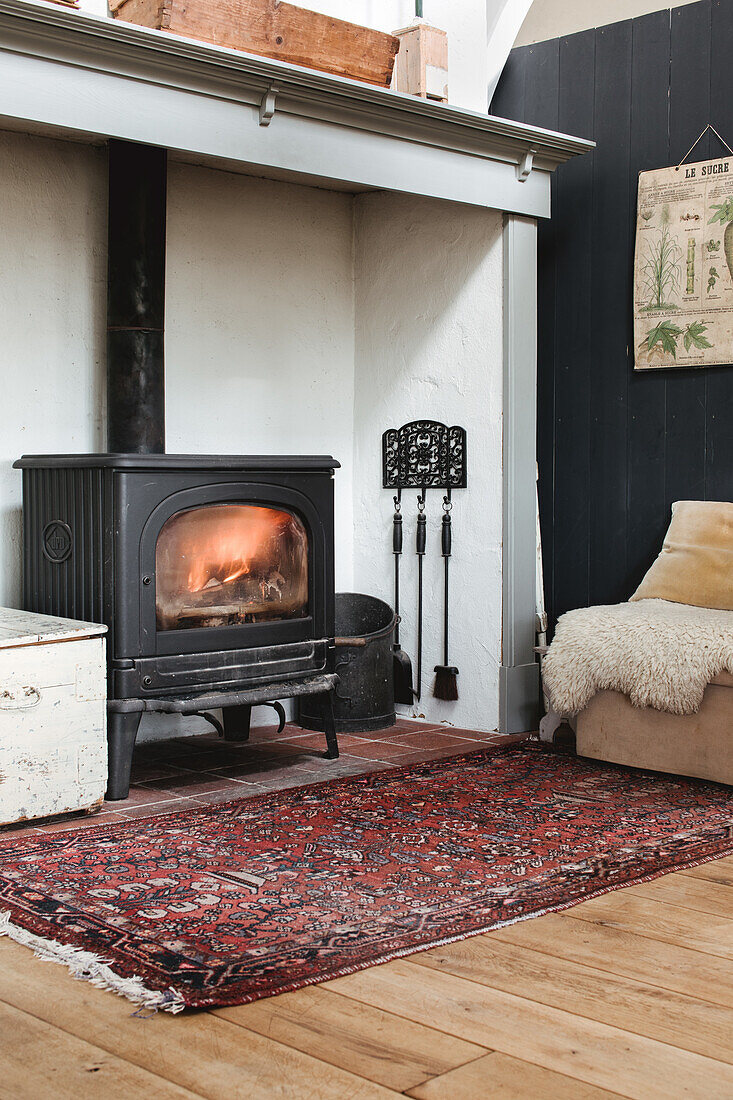 Cosy reading corner with wood-burning stove and oriental rug