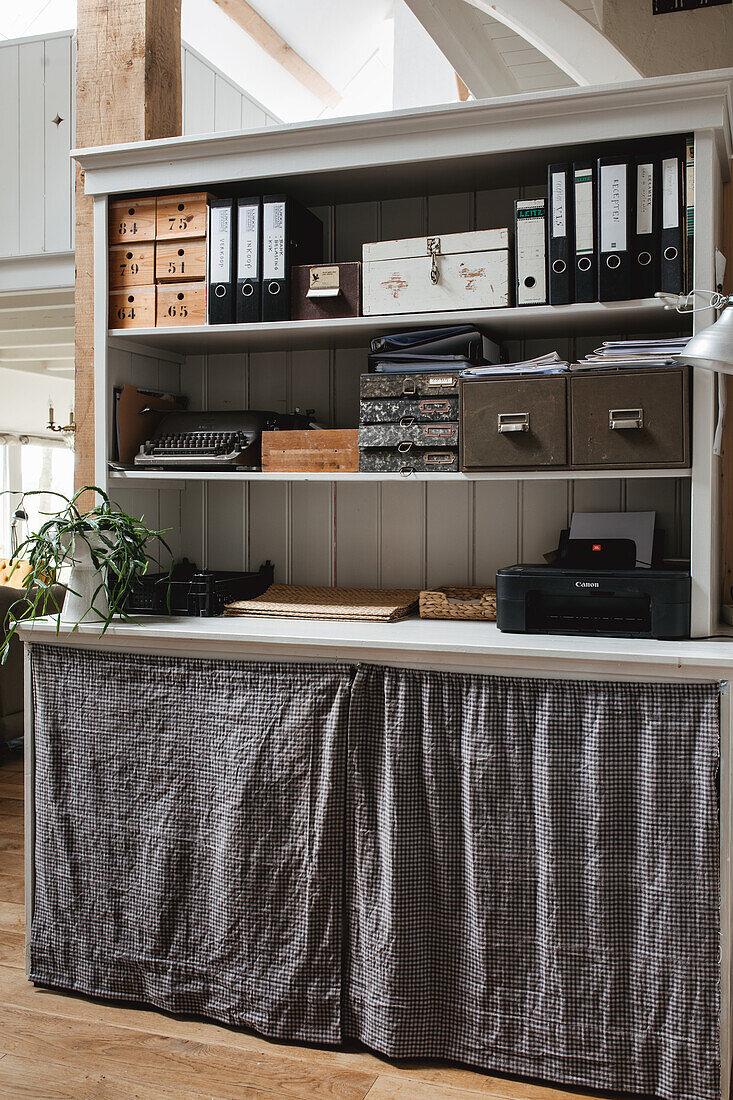 Organised workstation on shelf with curtain