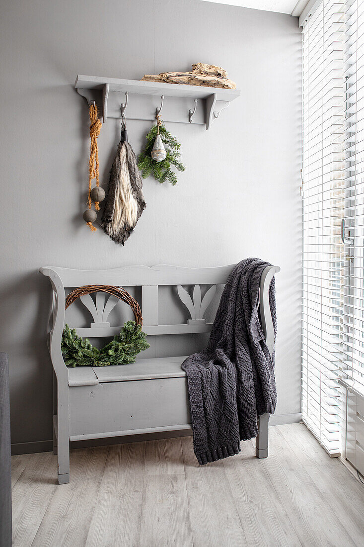 Grey wooden bench with woollen blanket and Christmas decorations