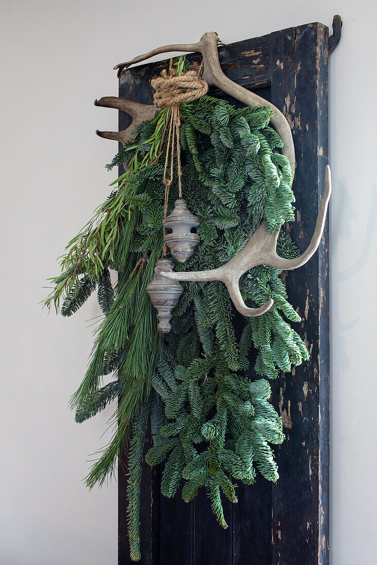 Rustic decoration with fir branches and deer antlers on window shutters