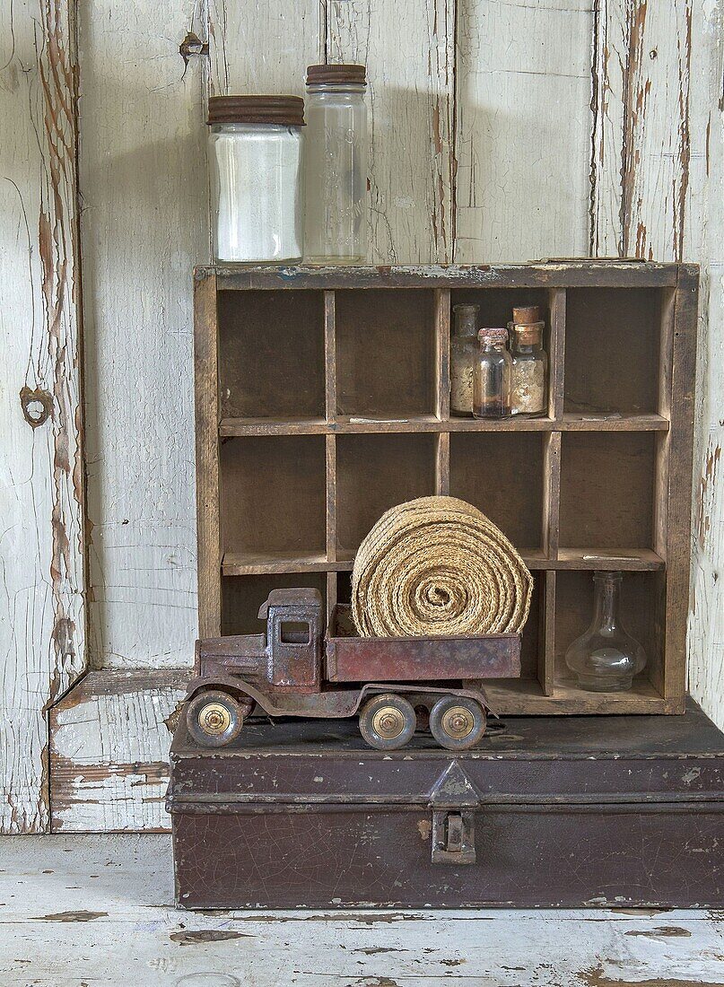 Vintage-Dekoration mit Spielzeug-Lkw und Flaschen in Setzkasten