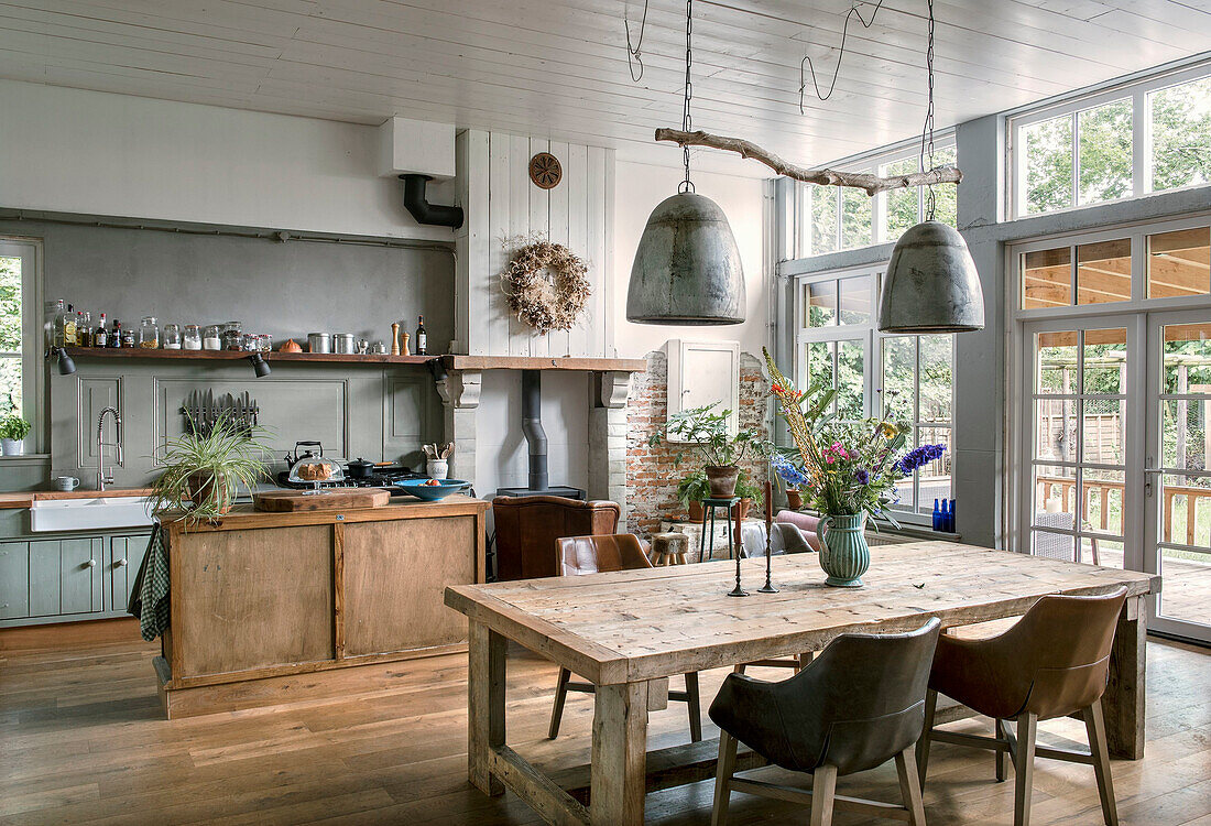 Open country kitchen with rustic wooden table and pendant lights