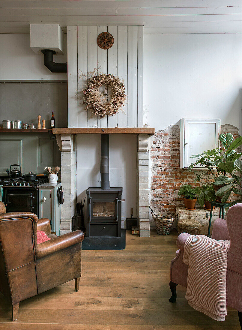 Living room with fireplace, leather armchair and dried flower wreath