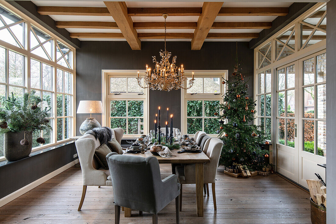 Dining room decorated for Christmas with wooden beams and chandelier