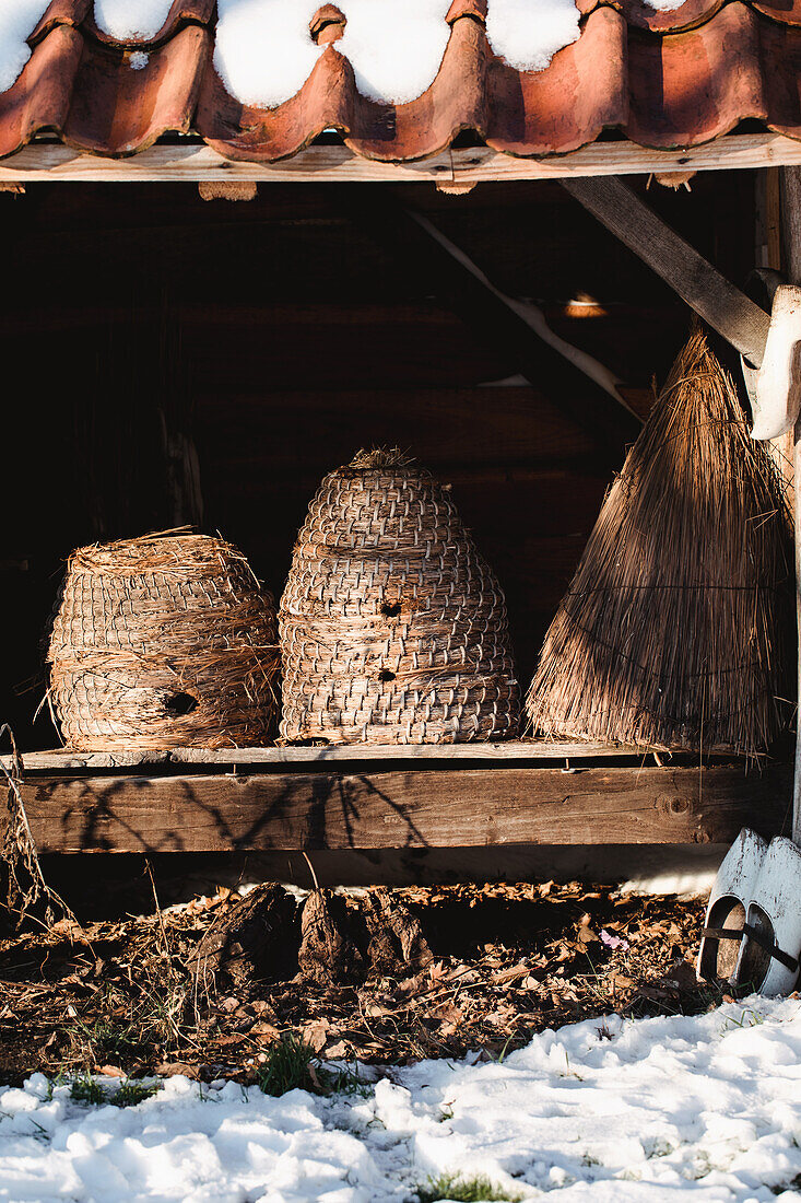 Bienenkörbe unter schneebedecktem Dach