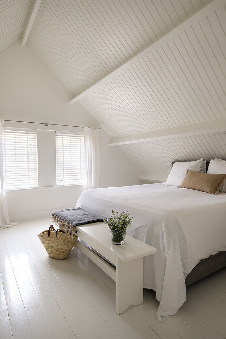 Bedroom under a sloping roof in Scandinavian style