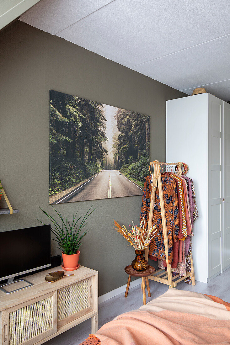 Living room with large-format print of Waldstrasse, rattan furniture and textiles