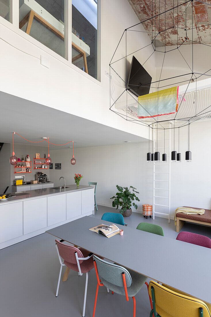 Modern dining room with colorful chairs and open kitchen