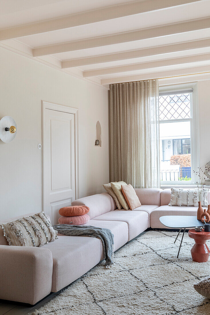 Pastel-colored living room with corner sofa and patterned carpet