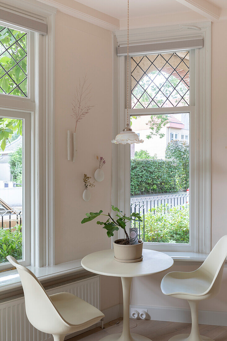 Sitting area with round table and chairs in front of large windows in a modern dining area