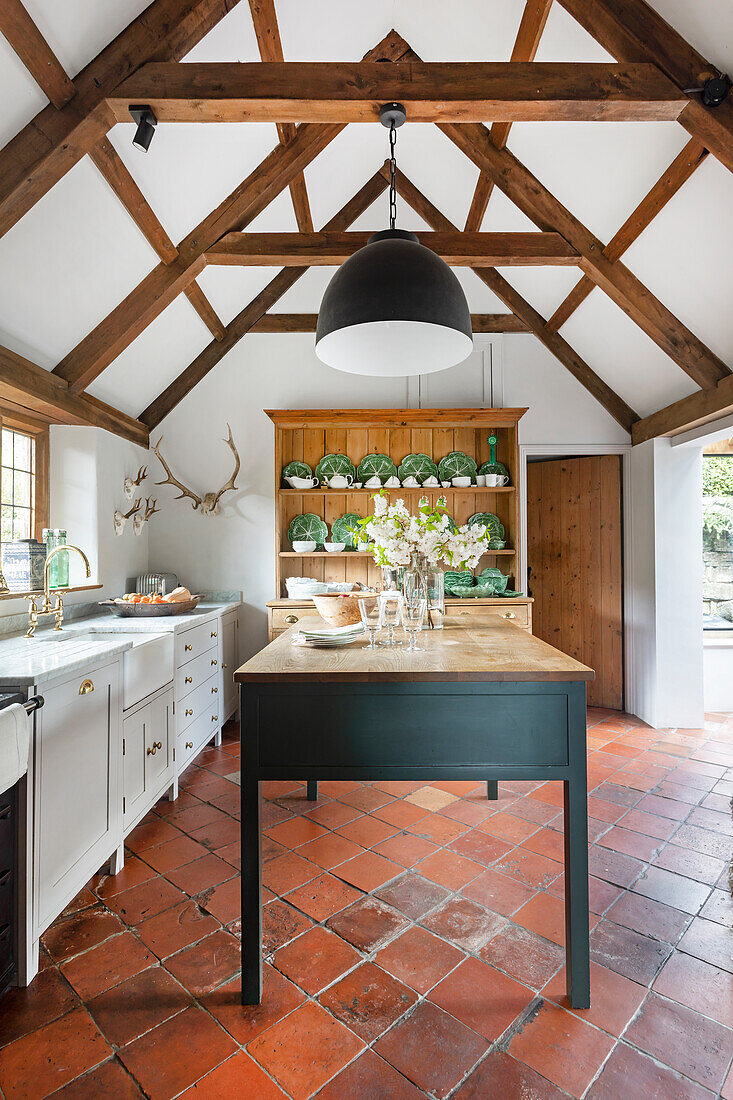 Country kitchen with wooden beamed ceiling and terracotta tiles