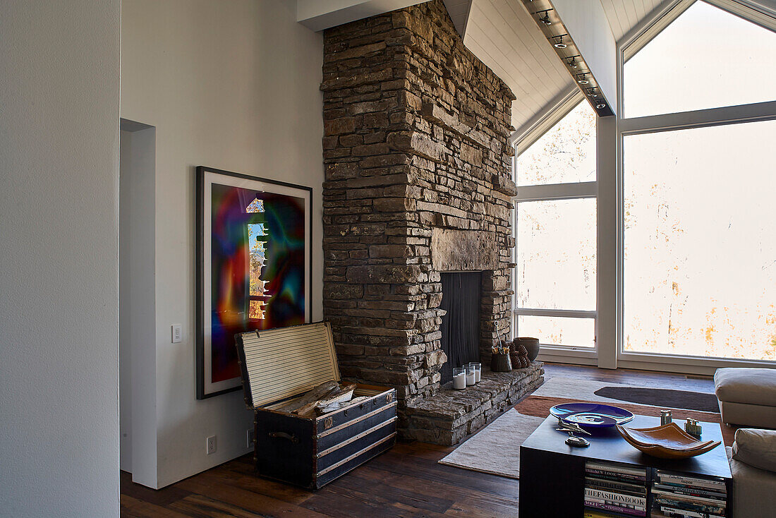 Living room and stone fireplace with full wall of windows