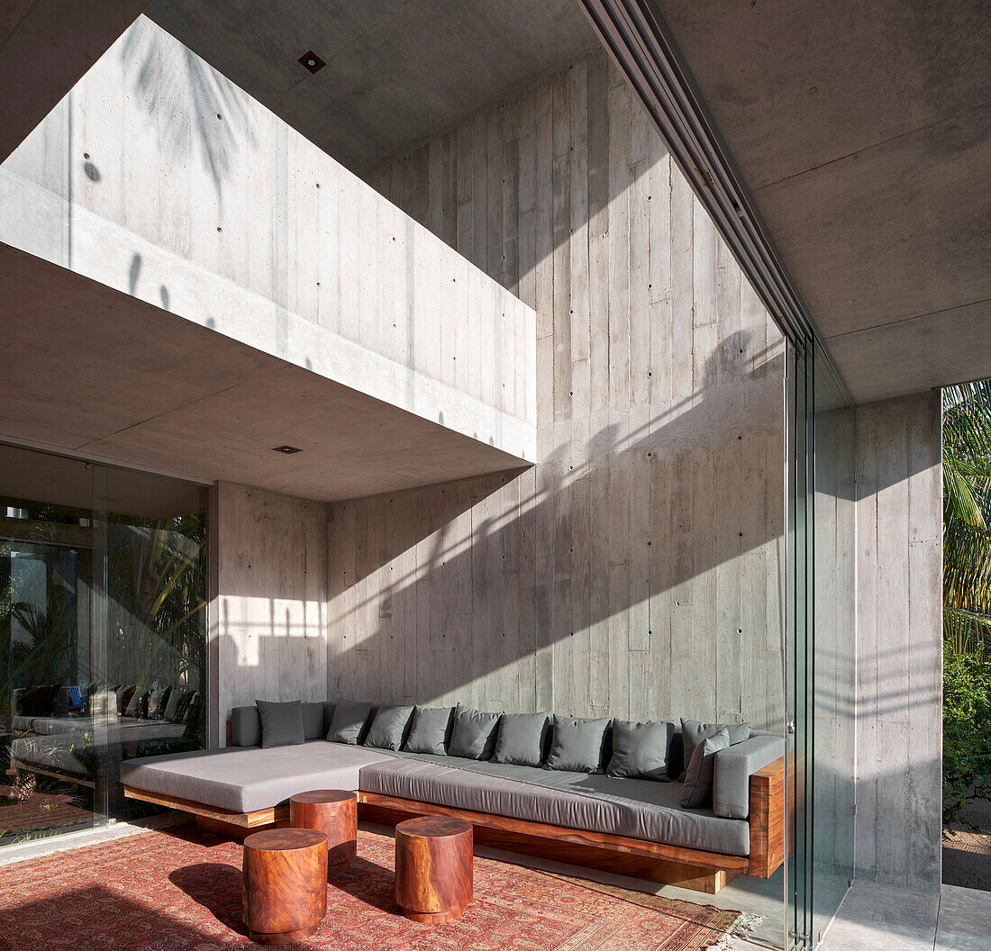 Sunlit living room with concrete walls and sliding glass door