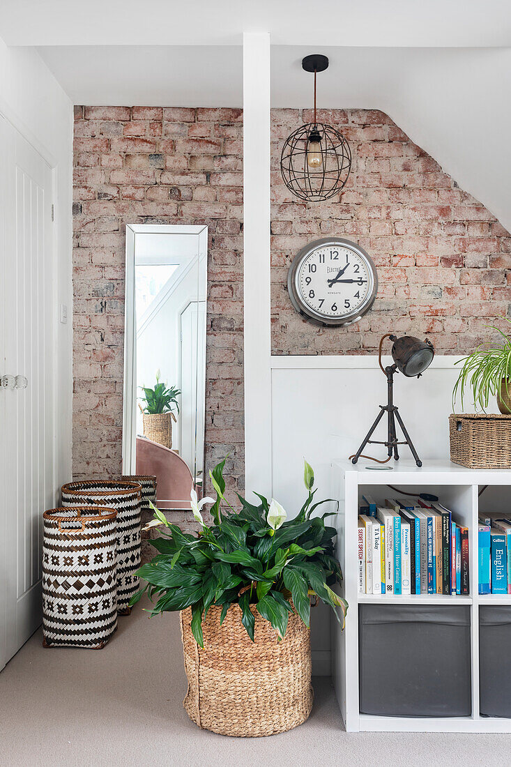 Room with brick wall, shelf and rattan basket with plant