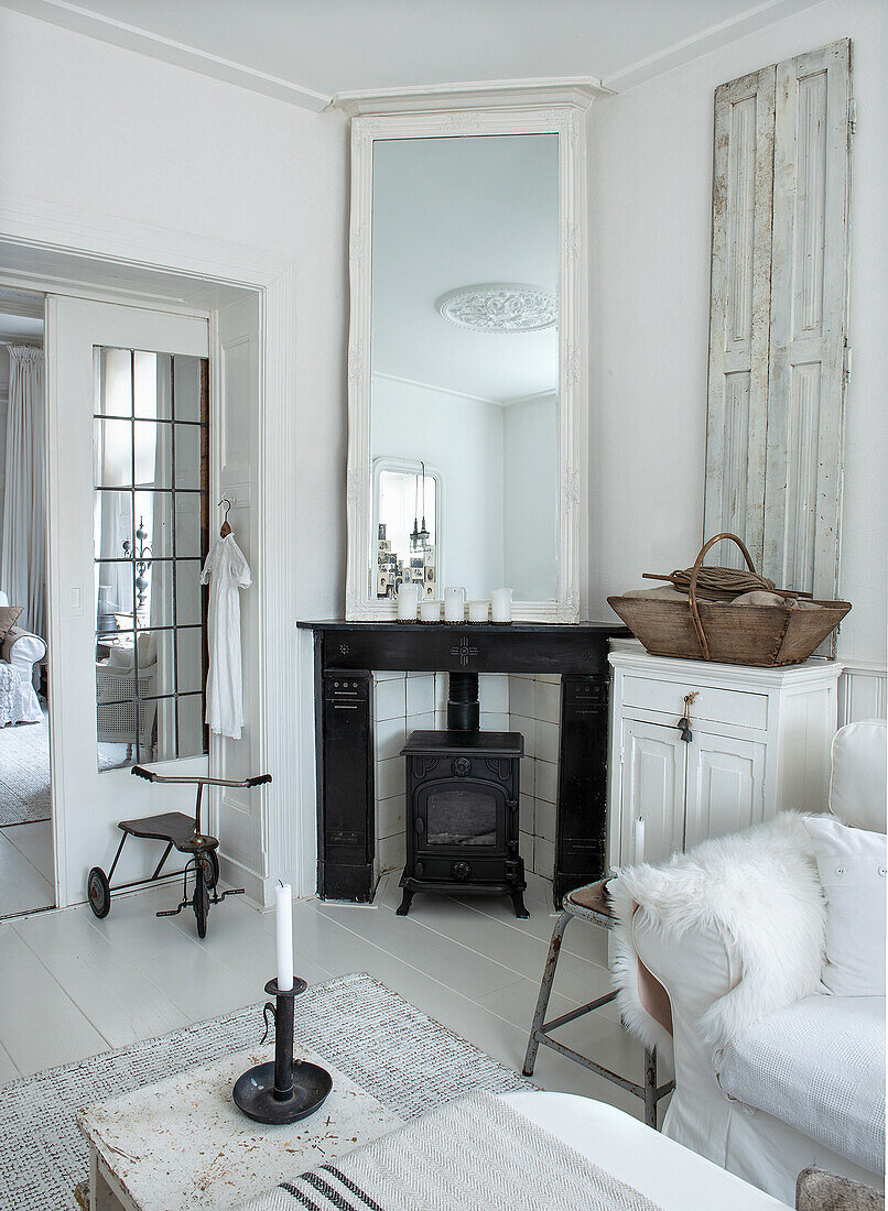 Scandinavian living room with fireplace and large mirror and white furniture