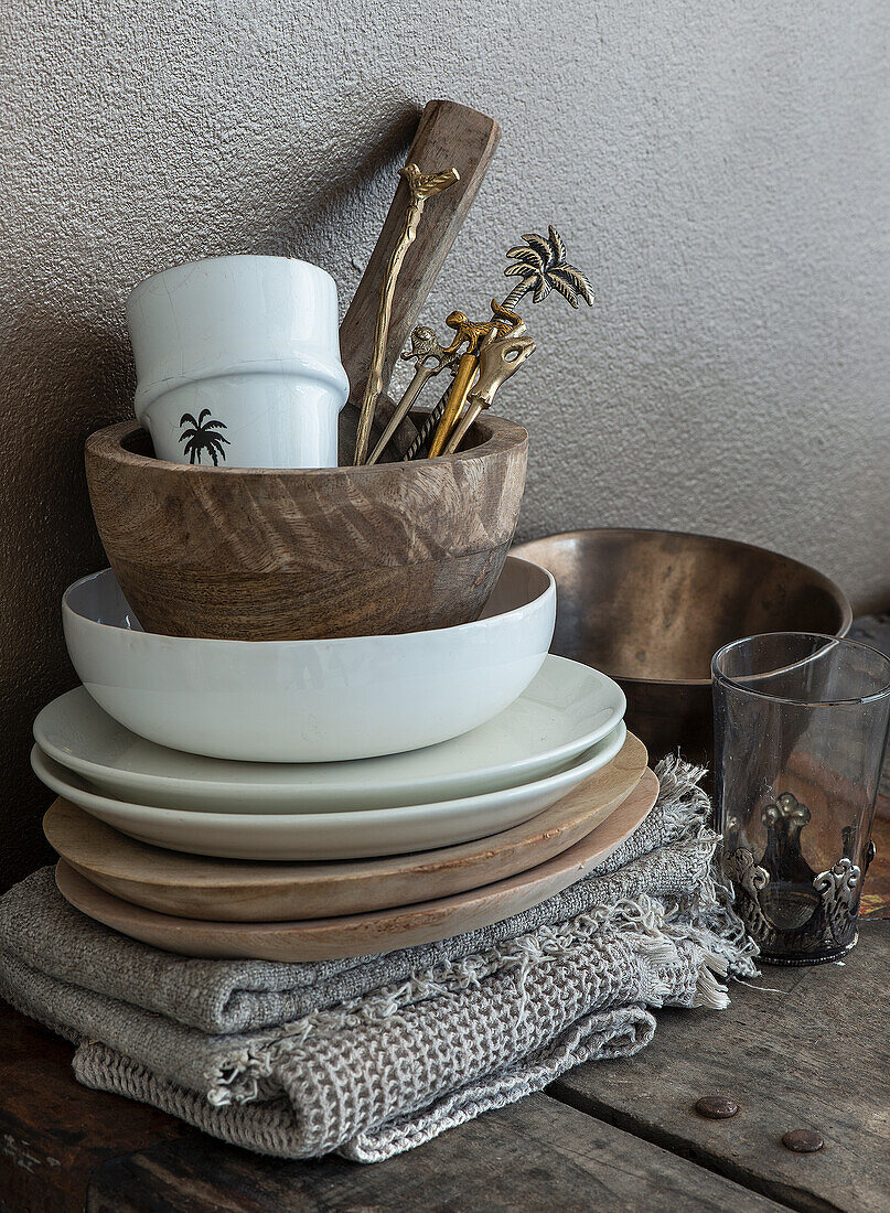 Wooden bowls and white ceramics on a folded knitted blanket