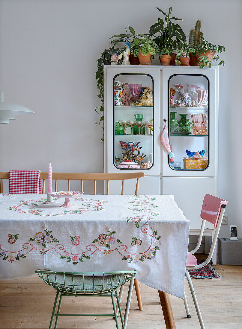 Essbereich mit bestickter Tischdecke und Vintage-Geschirrschrank