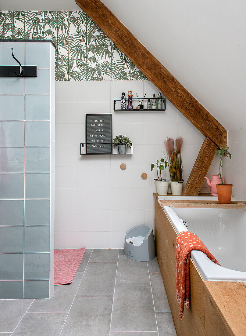 Modern bathroom with sloping ceiling, motif wallpaper and light blue tiles