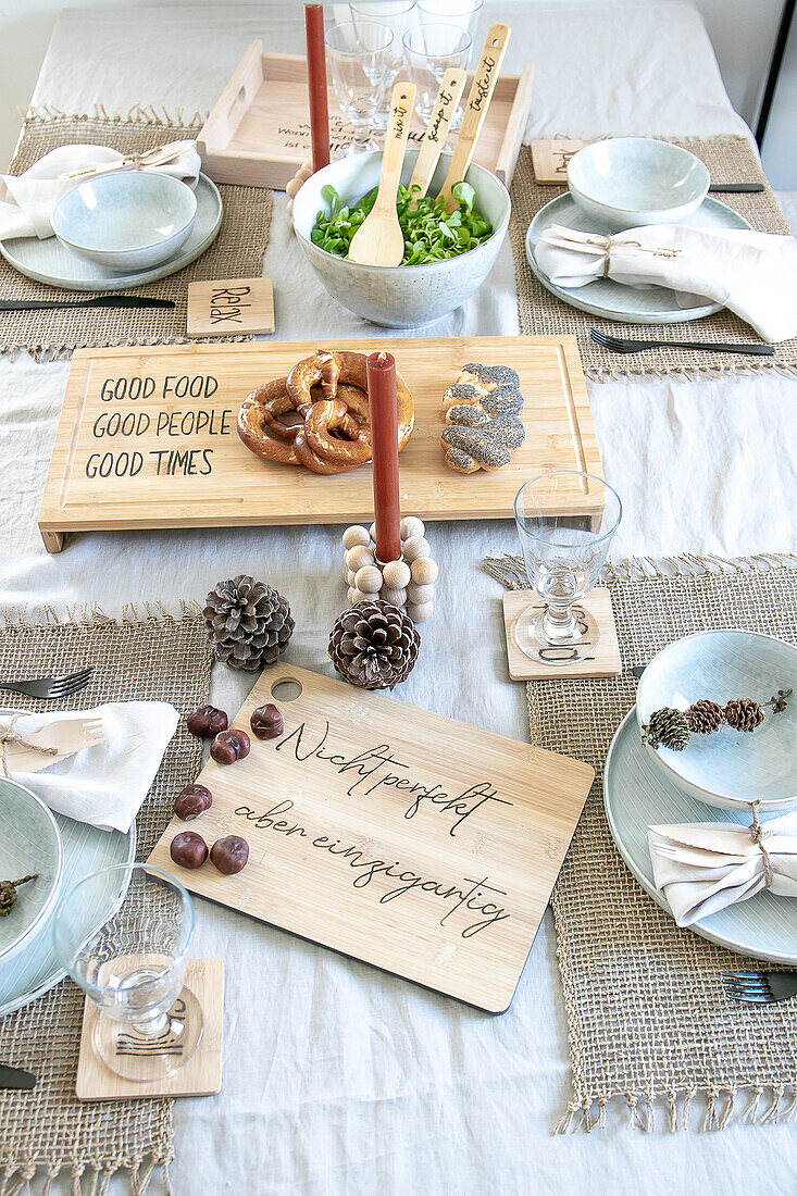 Festive table setting with wooden board, pretzels and candles