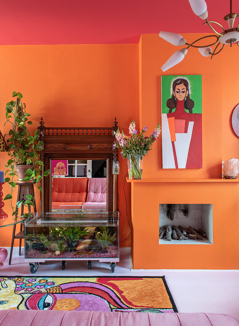 Living room with orange-colored wall, fish tank and fireplace