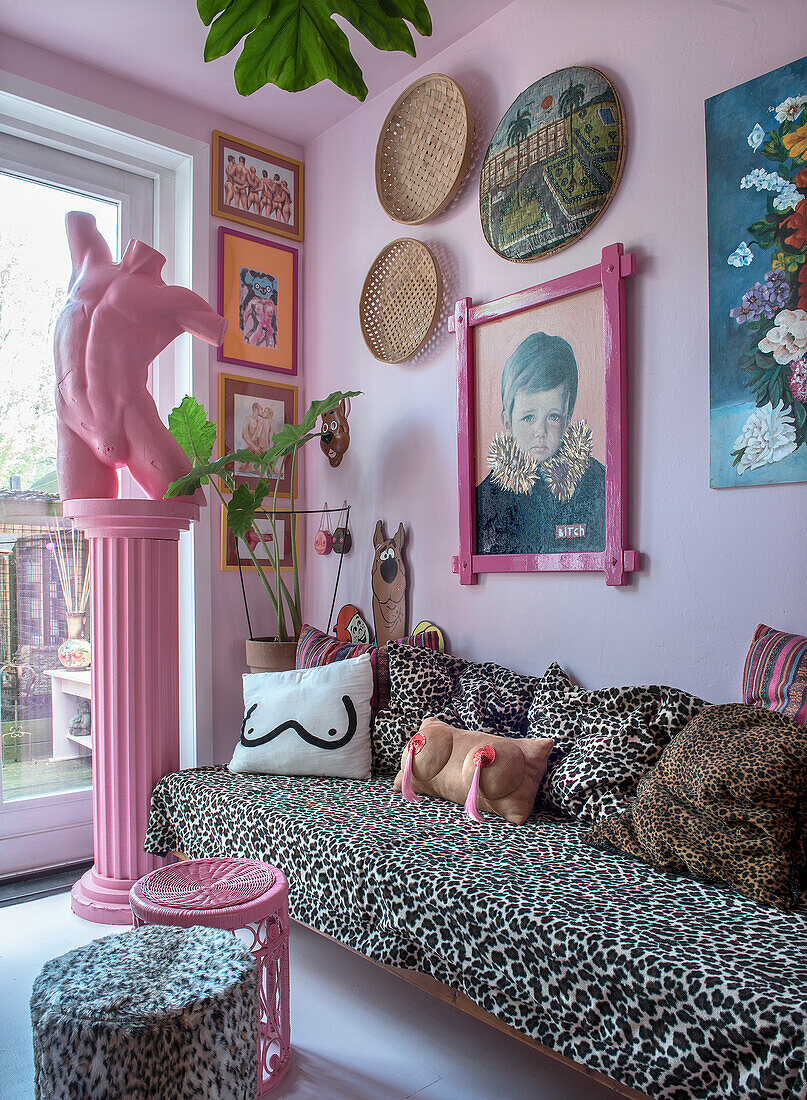 Living room with leopard print sofa, colorful wall decoration and pink accents