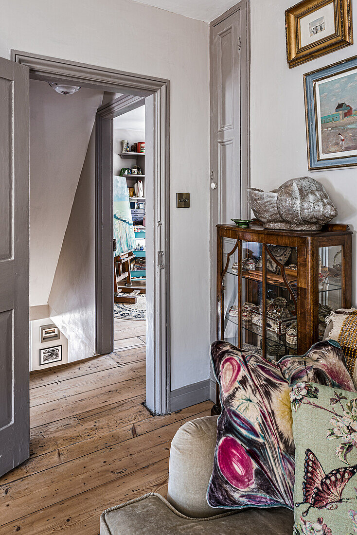 View of hallway with antique display cabinet and wooden floor in country house style