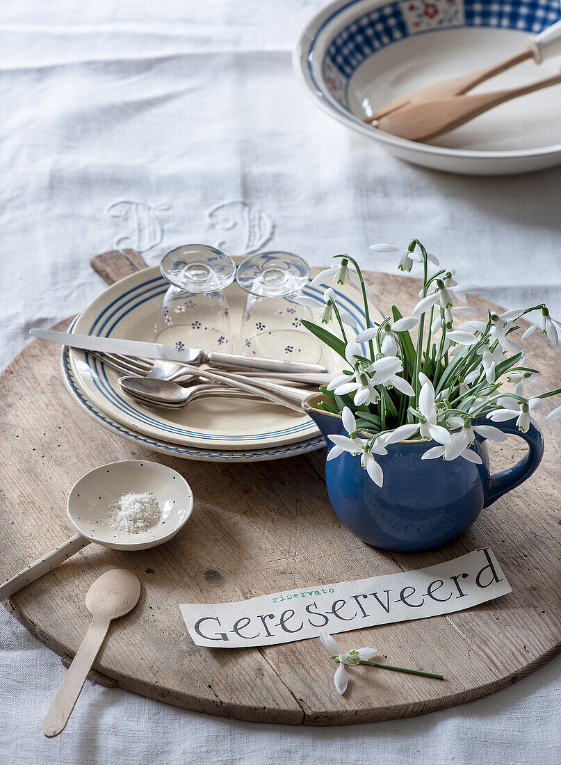 Frühlingshafte Frühstückstafel mit weißen Schneeglöckchen (Galanthus) in blauer Tasse