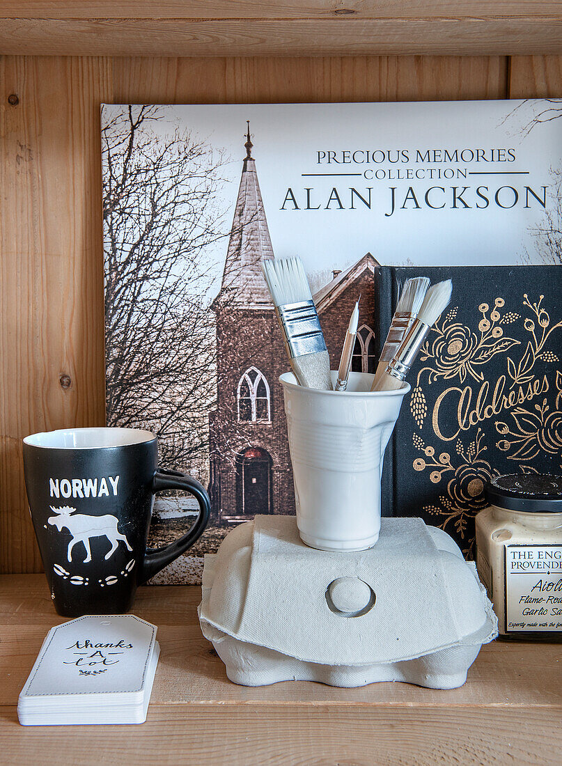 Shelf with Norway mug, brush holder, egg carton and various mementos