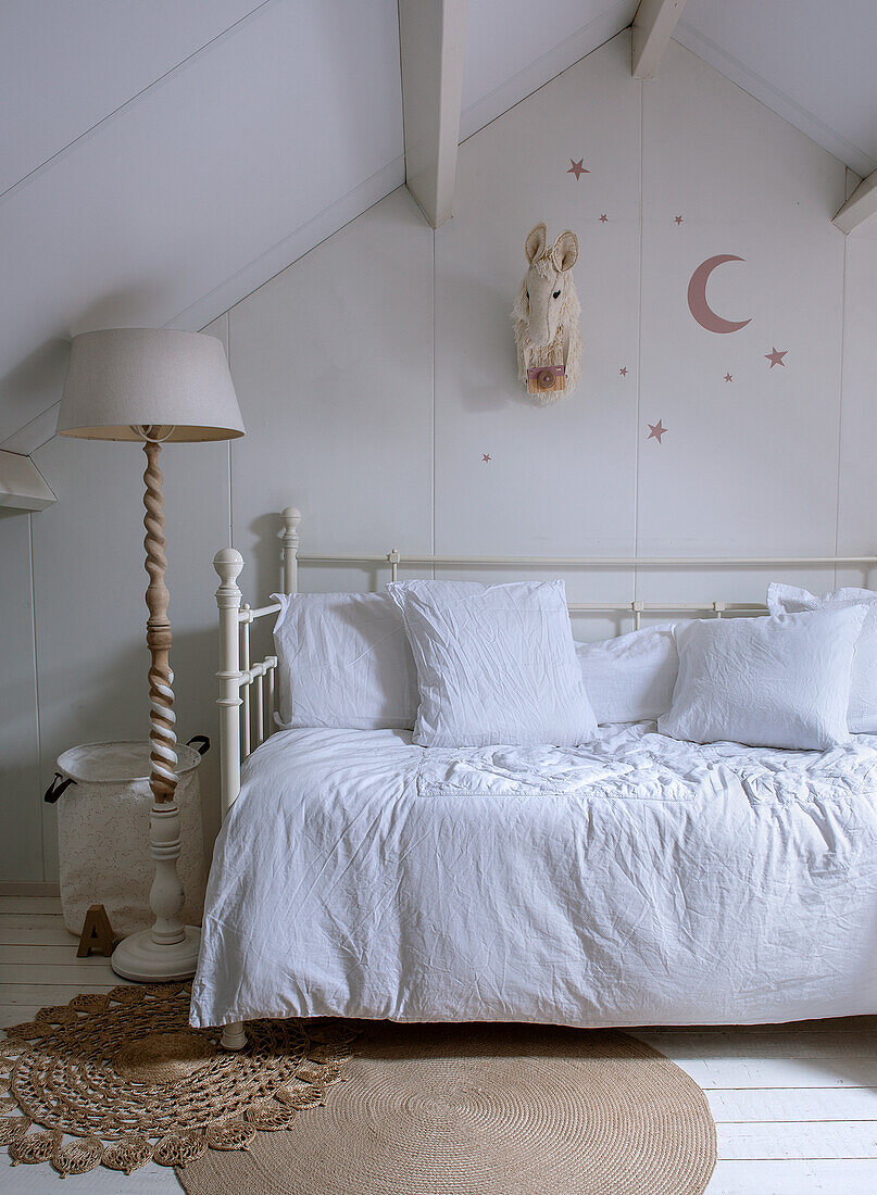 Bedroom with white metal bed in the attic