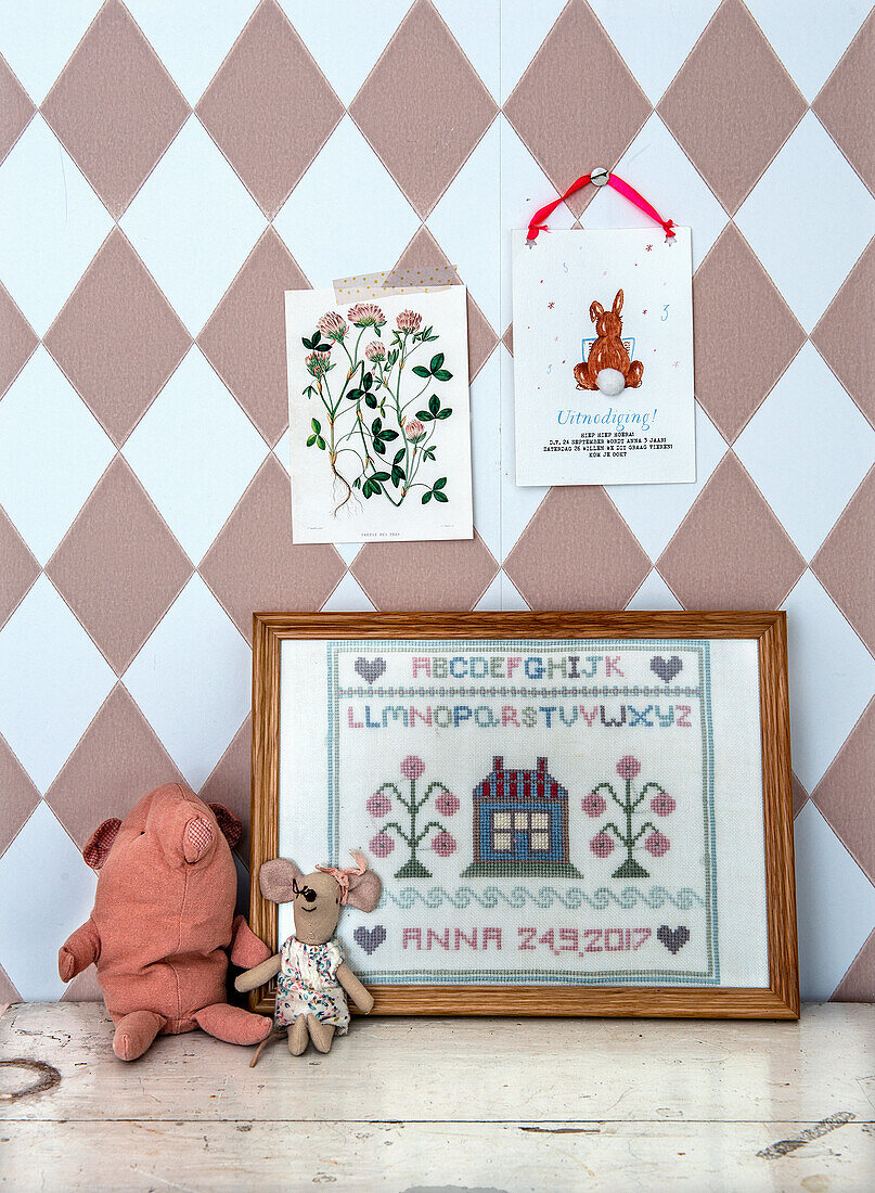 Children's room wall decoration with cross-stitch picture, postcards and soft toys