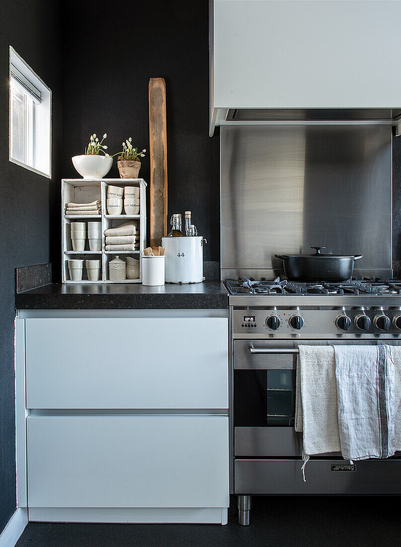 Kitchen with built-in stainless steel appliances and black wall color