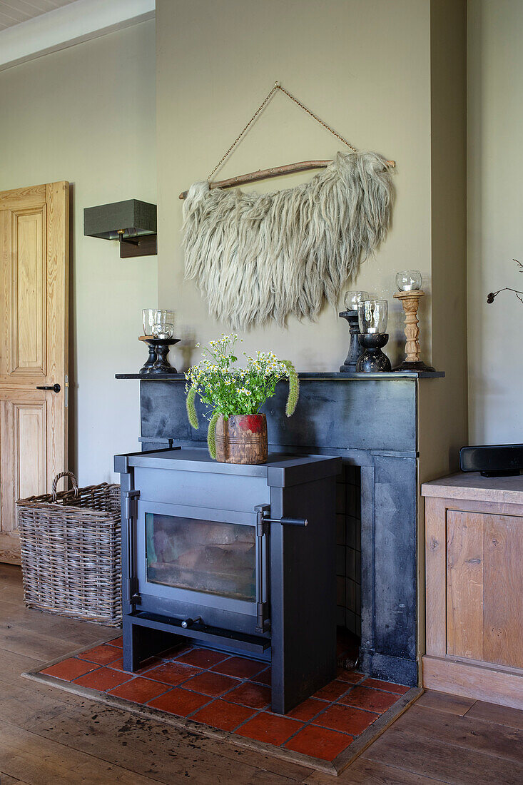 Wood-burning stove in cosy living room with decoration and fur wall hanging