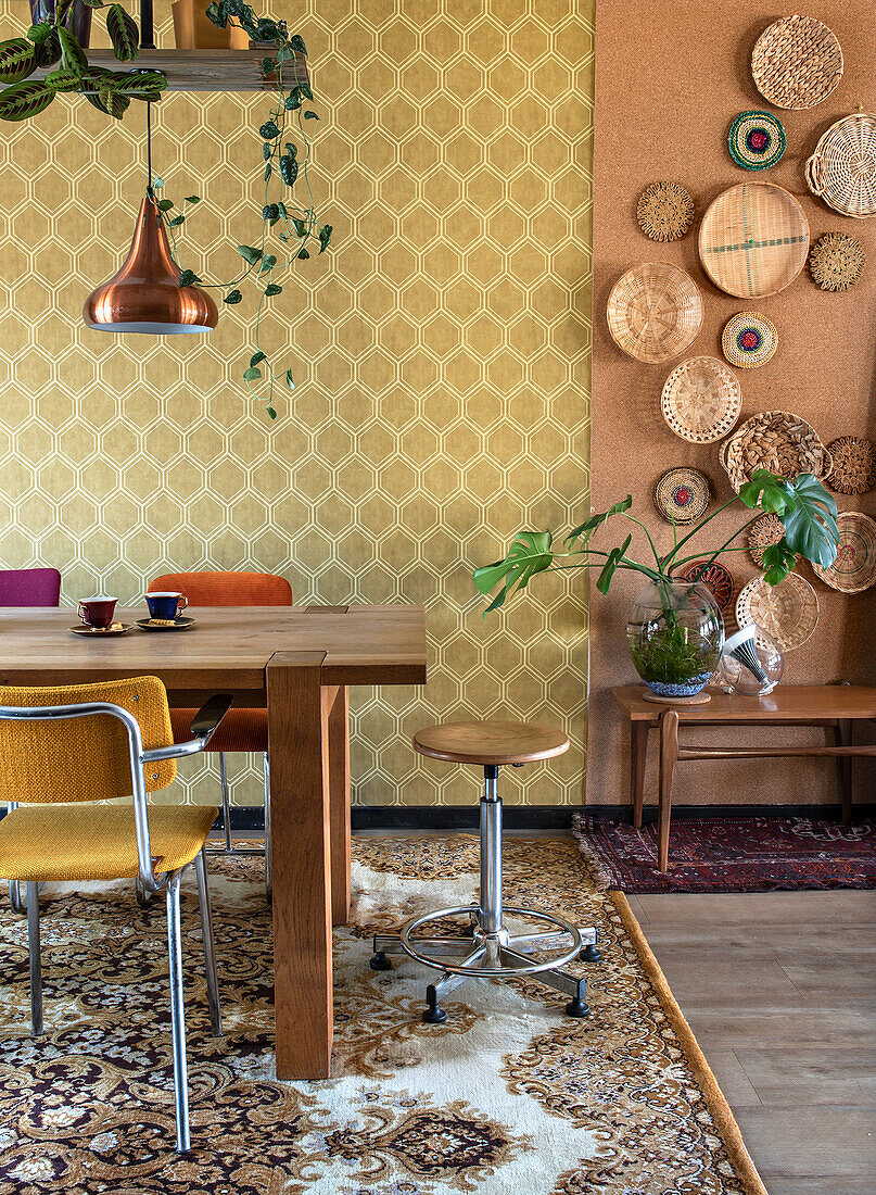 Dining area with wooden table, patterned rug and basket decoration on the wall