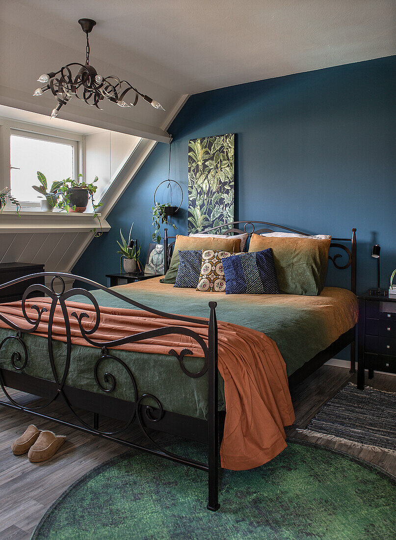 Spacious bedroom with green carpet and plants by the window