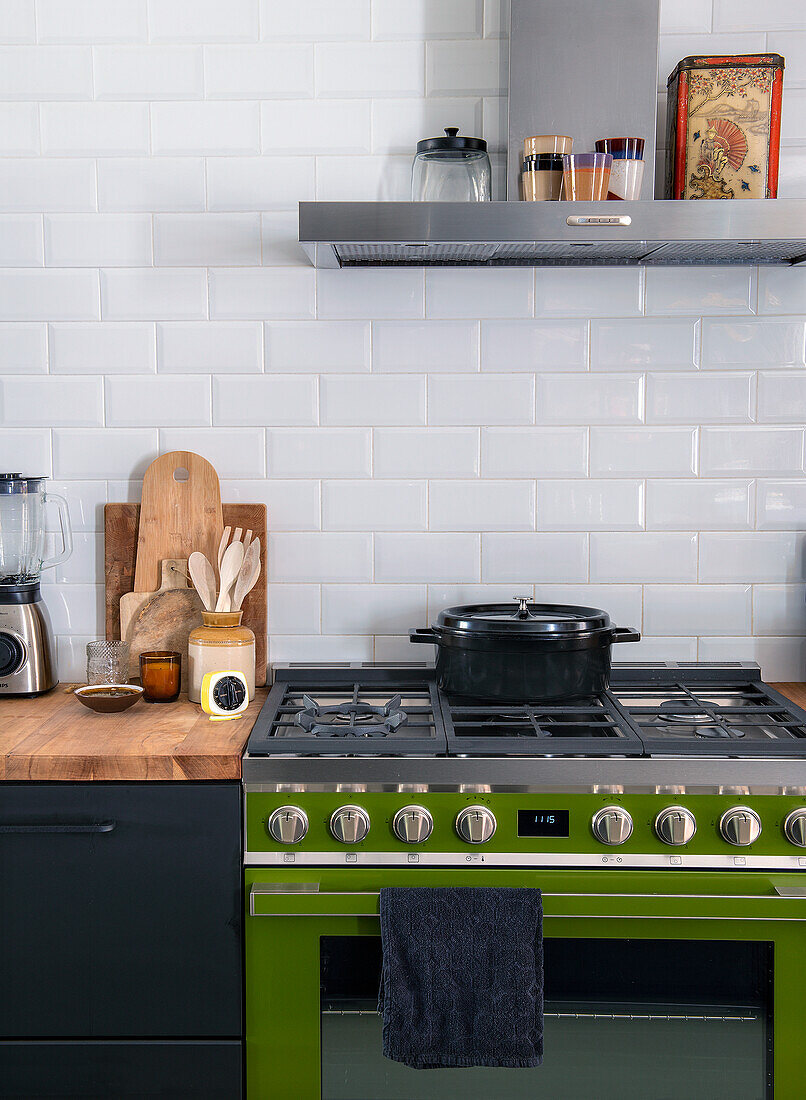 Modern kitchen with green gas oven and wooden accents