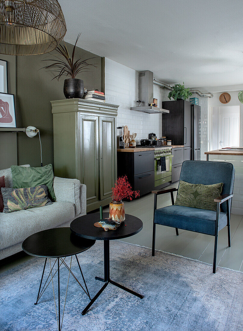 Living room with grey sofa, blue armchair and modern side tables